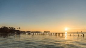 Beautiful day to night time lapse scene of a jetty with silhouettes of unknown people at sunset in Borneo Sabah, Malaysia. High resolution image and video available. Pan right motion timelapse.