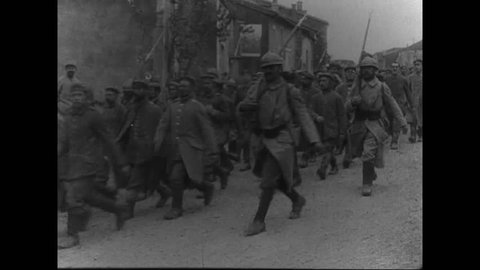 CIRCA 1916 - French soldiers march thousands of German POWs - infantrymen and officers - through a French town.