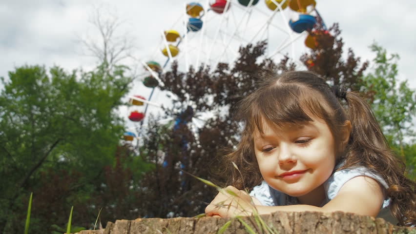 The child in the park is enjoying the sun. Portrait of a beautiful little girl.