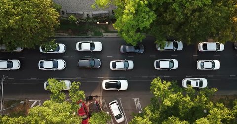 Aerial Drone Flight top down View of freeway busy city rush hour heavy traffic jam highway.  Aerial view of the vehicular intersection,  traffic at peak hour with cars on the road, fly under trees.