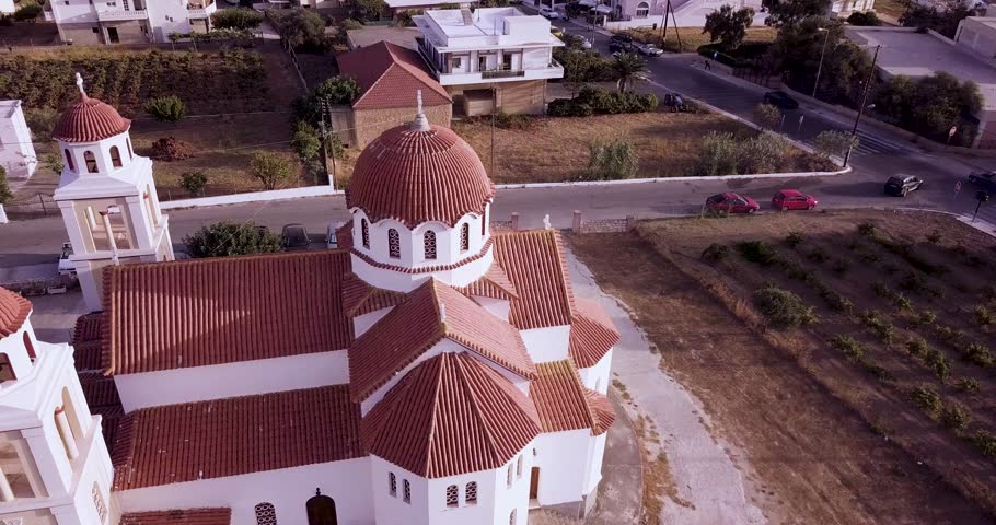 Flying around Ekklisia Agia Marina church in Crete. Beautiful greek temple with stunning dome and towers. Aerial view.