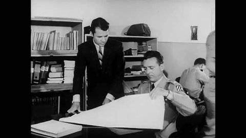 CIRCA 1962 - Audie Murphy's former company commander uses a map to show him the route of men in the 3rd infantry division, stationed in Germany.