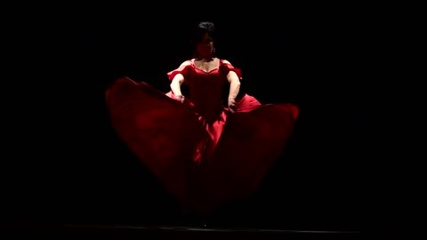 Girl is dancing the sexual movements of a flamenco dance. Black background. Slow motion