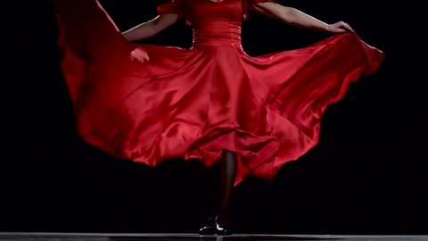 Flamenco. Dancer in the rhythm of the music develops her skirt. Black background. Close up. Slow motion
