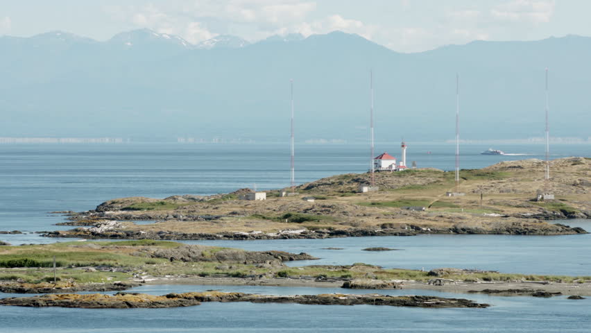 Trial Islands, Victoria 4K UHD. The lighthouse on the Trial Islands, near Victoria on Vancouver Island. The Olympic Mountain range, in Washington State, is in the background. 4K. UHD.
