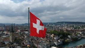 drone shot of Swiss flag waving in the wind over Grossmünster in Zürich, Switzerland - Powered by Shutterstock - Get 15% off with code: PIKWIZARD15