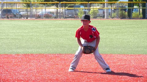 Slow motion video of youth baseball player making a play at shortstop
