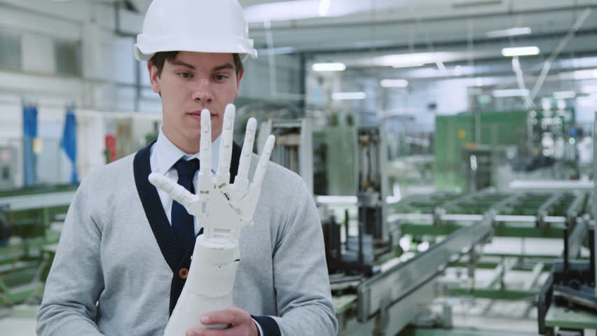 The engineer examines a robot hand on the factory. 4K.