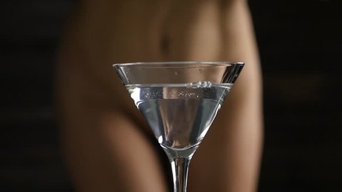 sexy young woman in a white panties prepares a cocktail with strawberry in a dark. close-up buttocks and hip. slow motion
