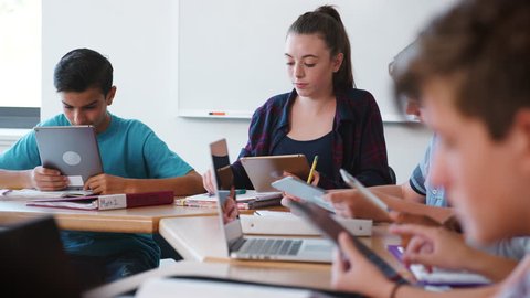 Female High School Student Receiving Individual Attention From Teacher In Class