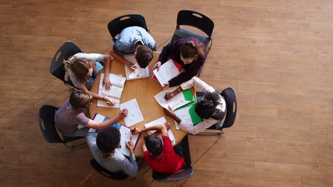 Overhead Shot Of High School Pupils In Group Study Around Table