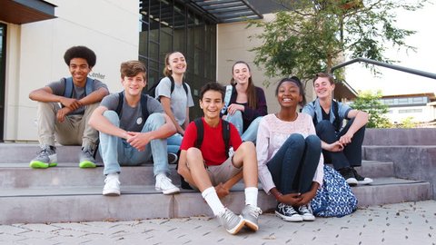 Portrait Of High School Student Group Sitting Outside College Buildings