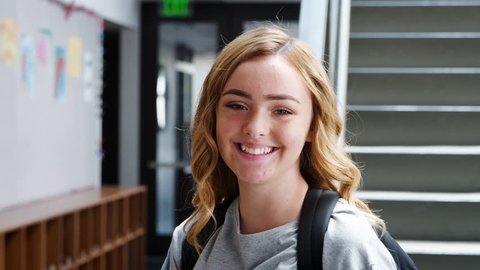 Portrait Of Female High School Student Standing By Stairs In College Building