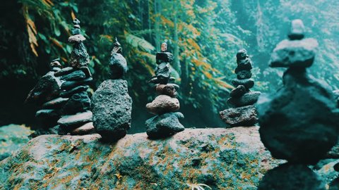 Stone zen balance towers in tropical jungle forest near waterfall