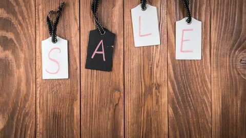 Sale on wooden label tags. Advertisement for a sale. Motion background with hanging price tags with Sale labels, stop motion, animation. Shopping sales and promotions concept