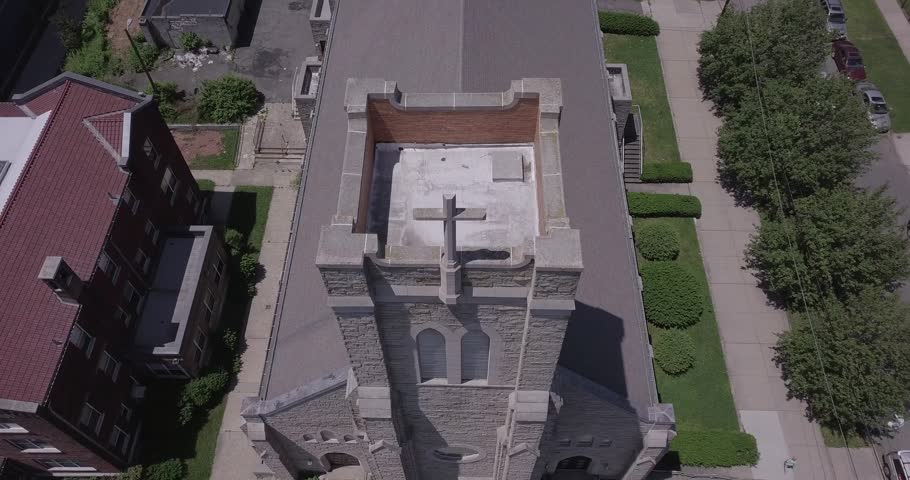 Top-down aerial view circles a demolished Jersey City church with a cross-shaped roof and surrounding residential blocks, 2018.