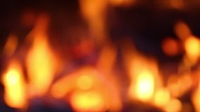 Close up view of blurry bright orange flame and burning wood in fireplace. Out of focus slow motion hd video footage. Christmas (Xmas) or New Year shiny blurry bokeh video background