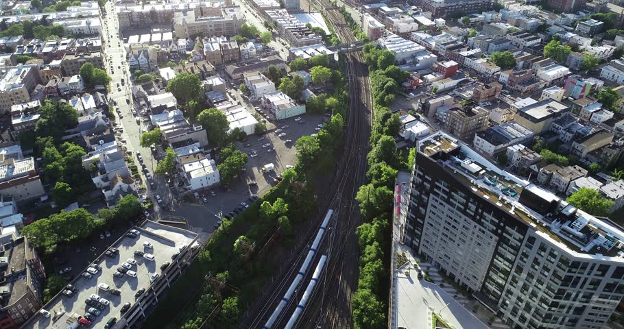 Aerial view across Jersey City rail lines, apartment blocks, streets, and the distant Manhattan skyline, 2018.