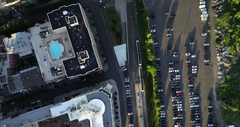 Top-down aerial view over Jersey City rooftops, pool deck, highway traffic, and Hudson waterfront towers, 2018.