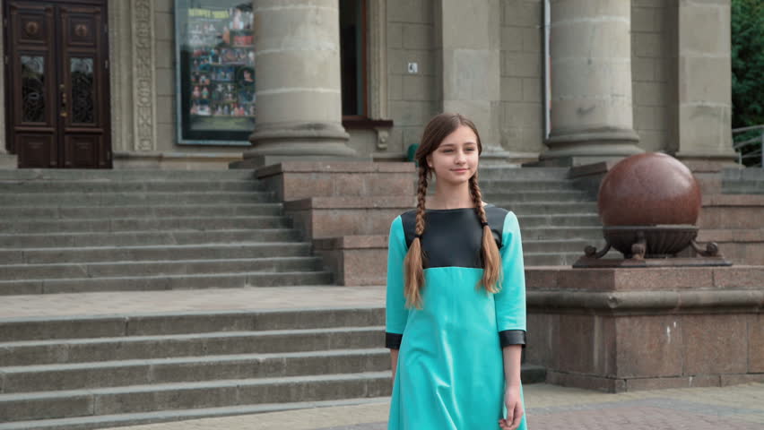 Young girl walks, poses and spinning on the city area. 4K