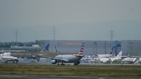 FRANKFURT AM MAIN, GERMANY - JULY 22, 2017: Airbus A340-313 D-AIFE of Lufthansa (Star Alliance Livery) landing at the foreground. Commercial airplane of American airlines accelerates on runway and