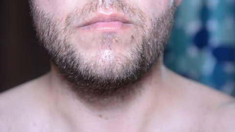 Man check and shaves his face. Man shaving with soap and manual razer. Close up of man shaving beard.