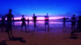 Silhouettes playing soccer on the beach in an abstract defocus multiple exposure sunset scene