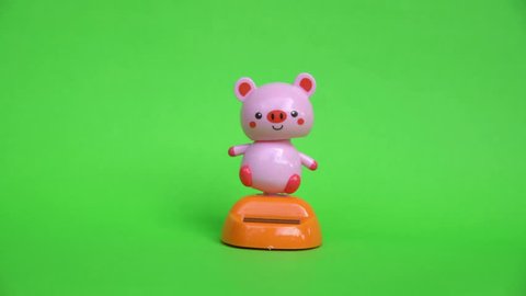 Pink pig doll dancing on green screen background.