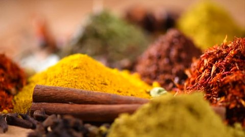 Spices. Various Indian Spices on wooden table. Spice and herbs rotated on wood background. Assortment of Seasonings, condiments. Cooking ingredients, flavor. Slow motion 4K UHD video