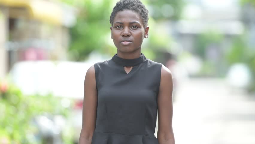 Young beautiful African businesswoman with arms crossed outdoors