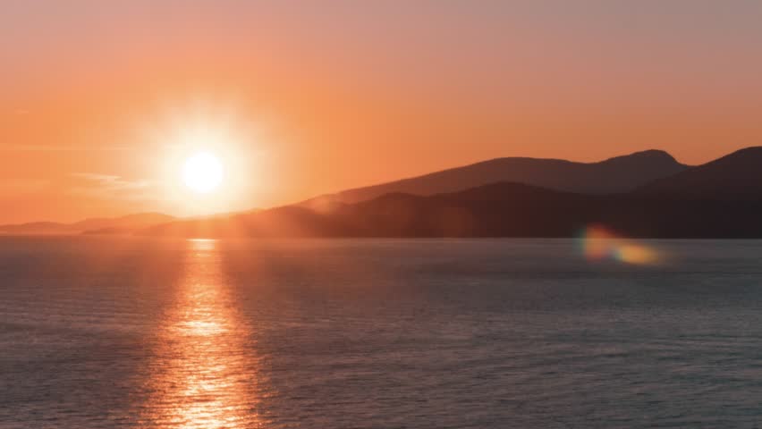 A beautiful sunset falling behind mountains viewed from an outlook in UBC, Vancouver, BC, Canada. Timelapse.