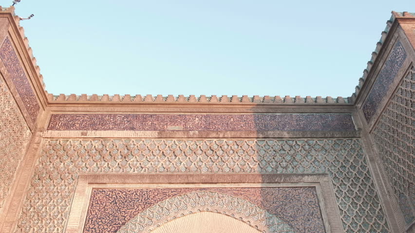Camera tilt down view from top to bottom of Bab Mansour Gate wooden door in Meknes, Morocco late afternoon