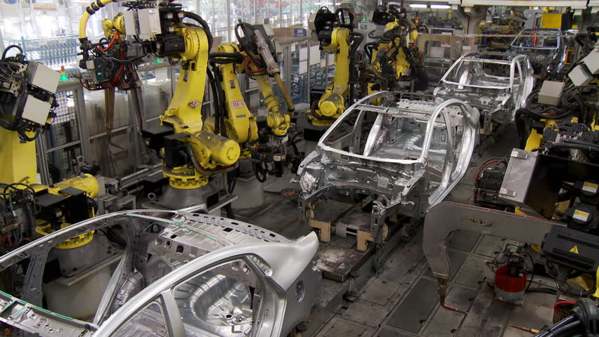 Robotic line at the automobile plant. Robot manipulators collect and weld car bodies