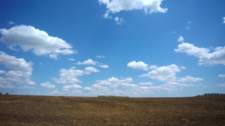 male athlete running across the field against a background of clouds