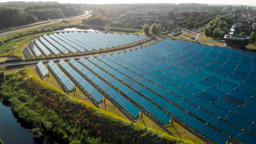 Aerial view of a solar panel farm arranged in a circular pattern with a bus road in the middle, producing green reviewable energy for a modern city district Noorderplassen in Almere, The Netherlands Royalty-Free Stock Footage #1013657294