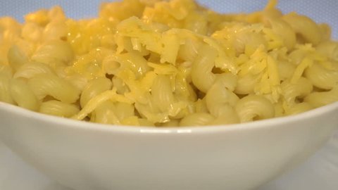 Bowl of cooked pasta macaroni and cheese. Making mac and cheese in the microwave close-up. Bowl warming up during microwaving.