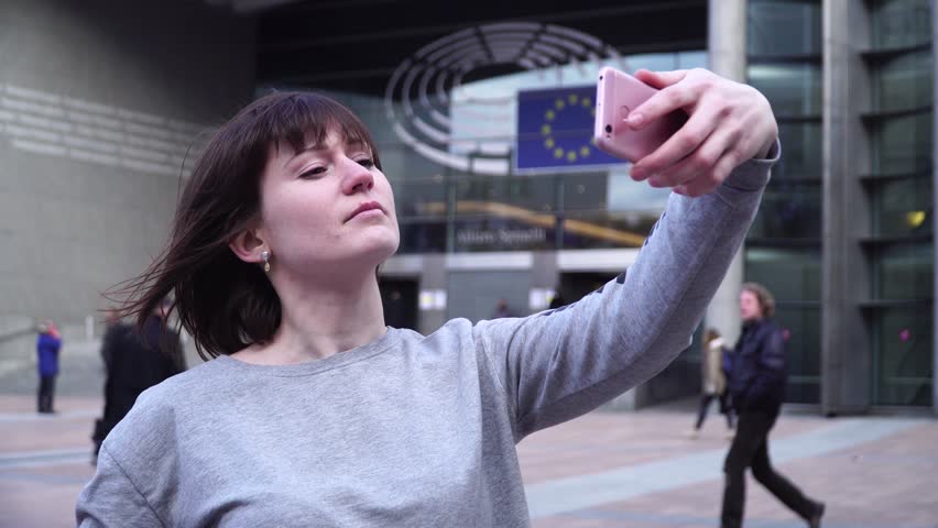 Woman tourist takes pictureson on smartphone near the European Parliament in Brussels. Belgium.
