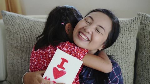 Daughter give mom the surprise greeting card,Concept of Mother day in slow motion footage