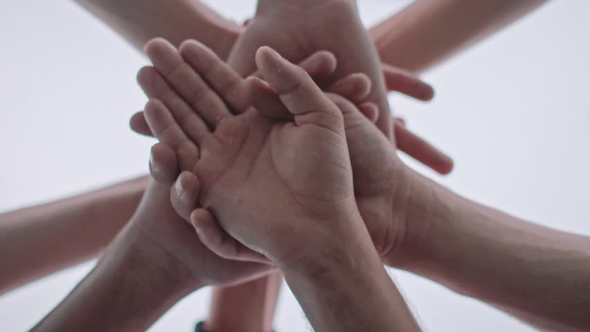 Low angle shot of a team doing a hands in cheer before the big game. Huddle. Royalty-Free Stock Footage #1013671835