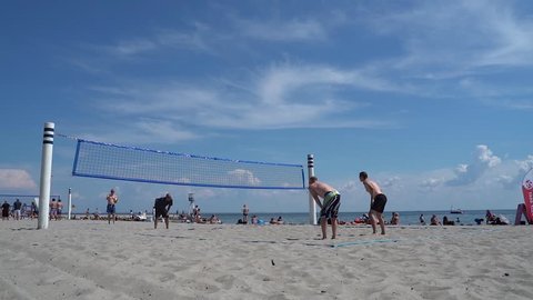 Copenhagen, Denmark, July 12,2018; Bellevue beach, the most famous tourist nude beach in Copenhagen. Group of tourists are playing beach volleyball. Seen in slow motion shot.