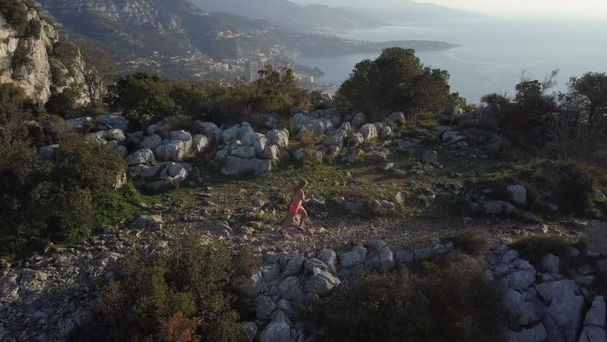 girl running on french rivera near monaco , aerial video