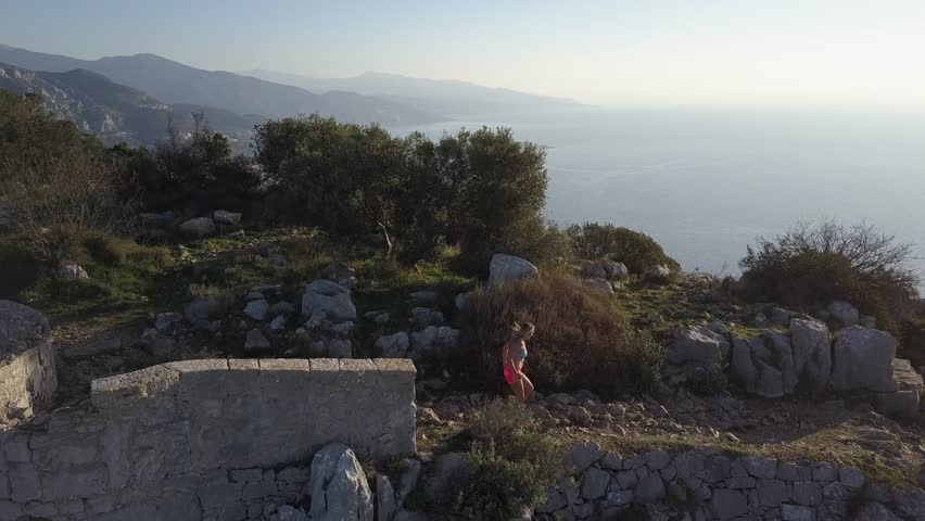 girl running on french rivera near monaco , aerial video