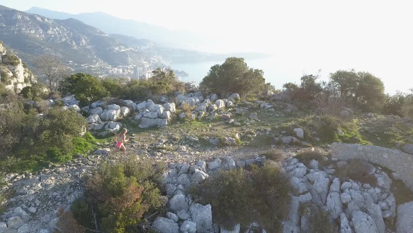 girl running on french rivera near monaco , aerial video