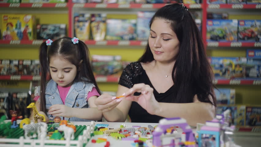 Little charming girl with her mother is playing with a children