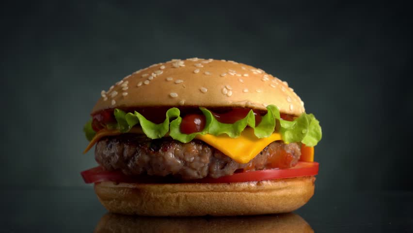 Beef Burger rotating on the table on a black background. | Shutterstock HD Video #1013704019