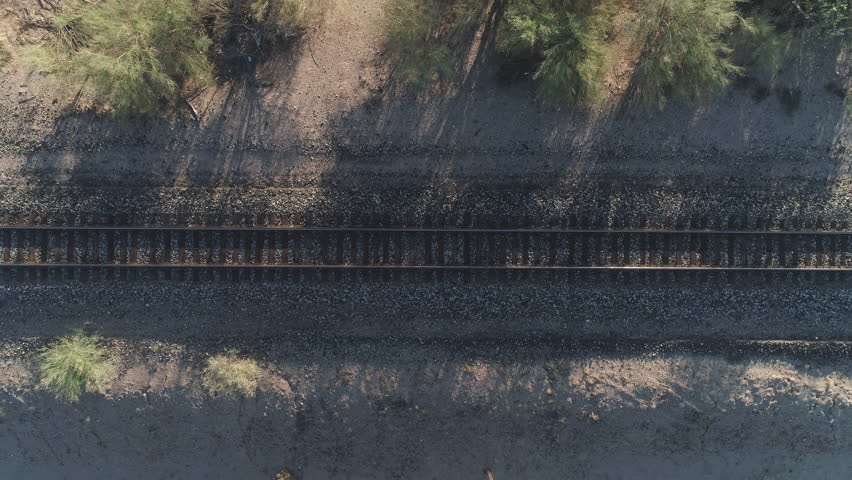 4K Aerial Zoom Down of Desert Train Tracks at Sunrise