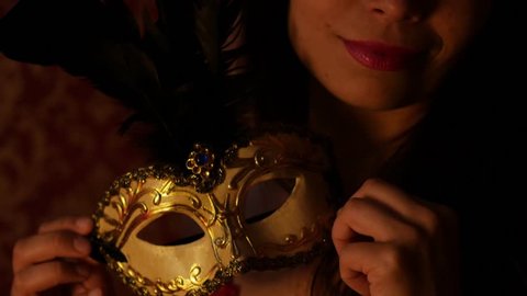 mysterious woman holding gold venetian mask, night, dusk