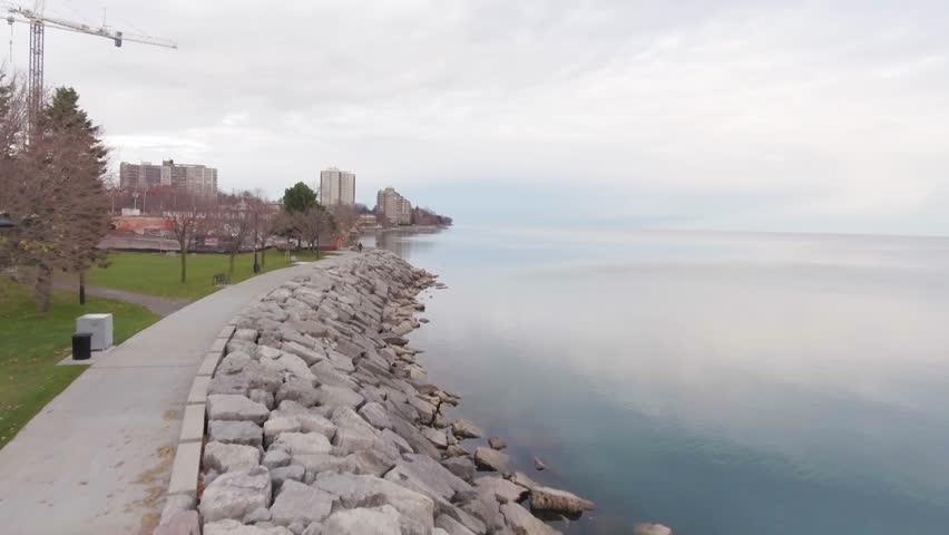 Smooth sunset aerial by the edge of the Burlington Ontario Lake. Half water half land. Five meters above sea level.