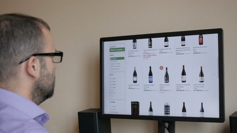 A man orders red wine home in an online store. The businessman selects the alcohol in the grocery online store. 4K UHD. New York, July - 2018