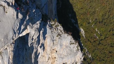 Aerial shot of a man base jumping in slow motion from a cliff in choranche vercors massif France. 